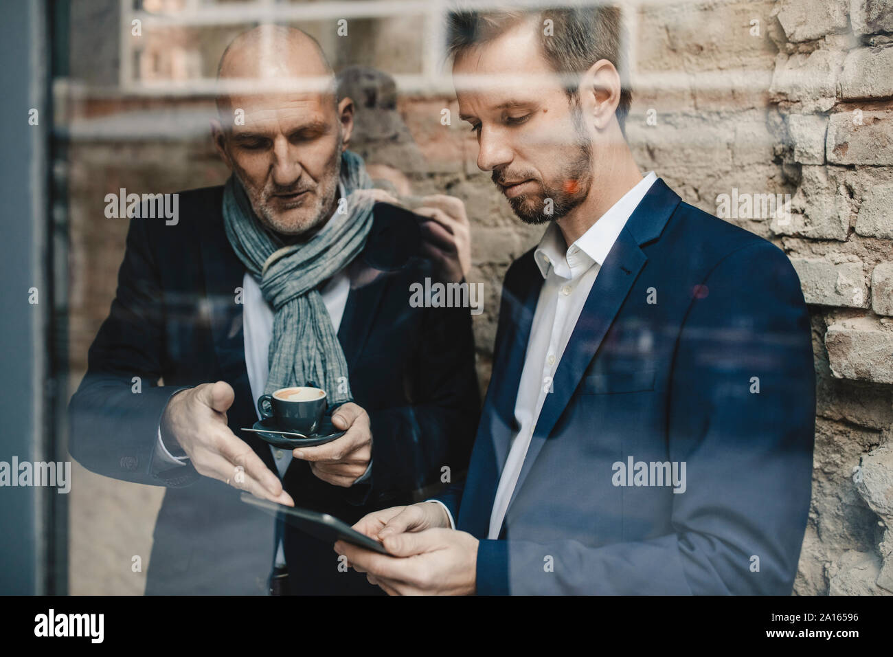Senior and mid-adult businessman sharing a tablet Stock Photo