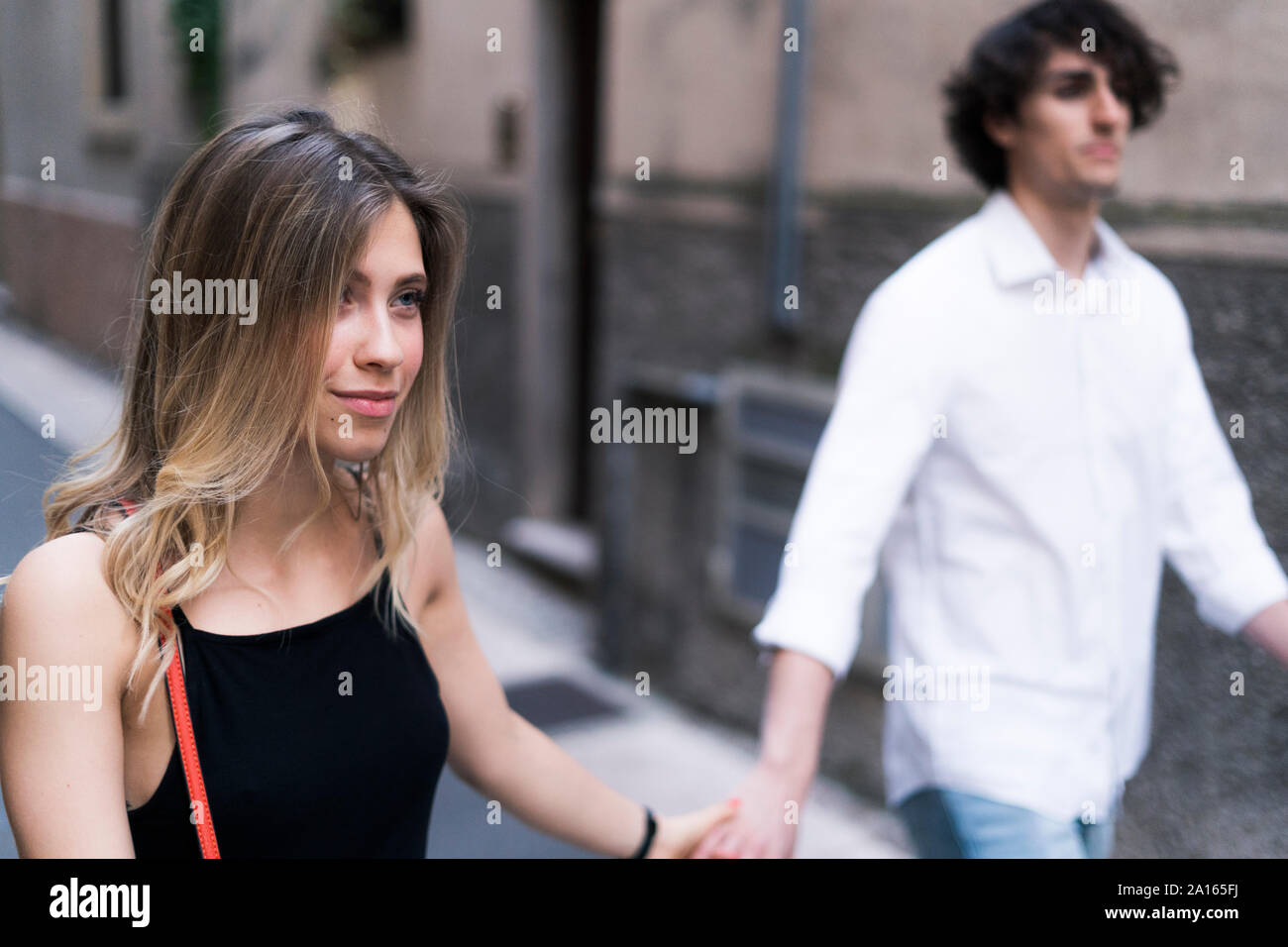 Young couple walking hand in hand in the city Stock Photo