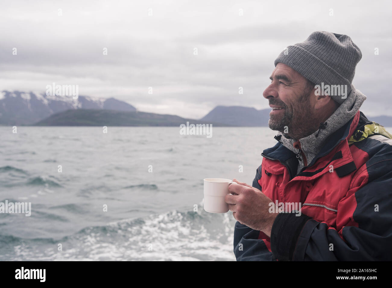 Mature man looking at the sea, boating on Eyjafjordur Fjord, Iceland Stock Photo
