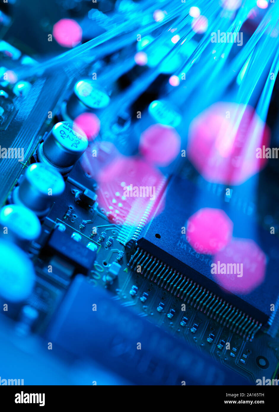 Fibre optics carrying data passing across electronic circuit board Stock Photo