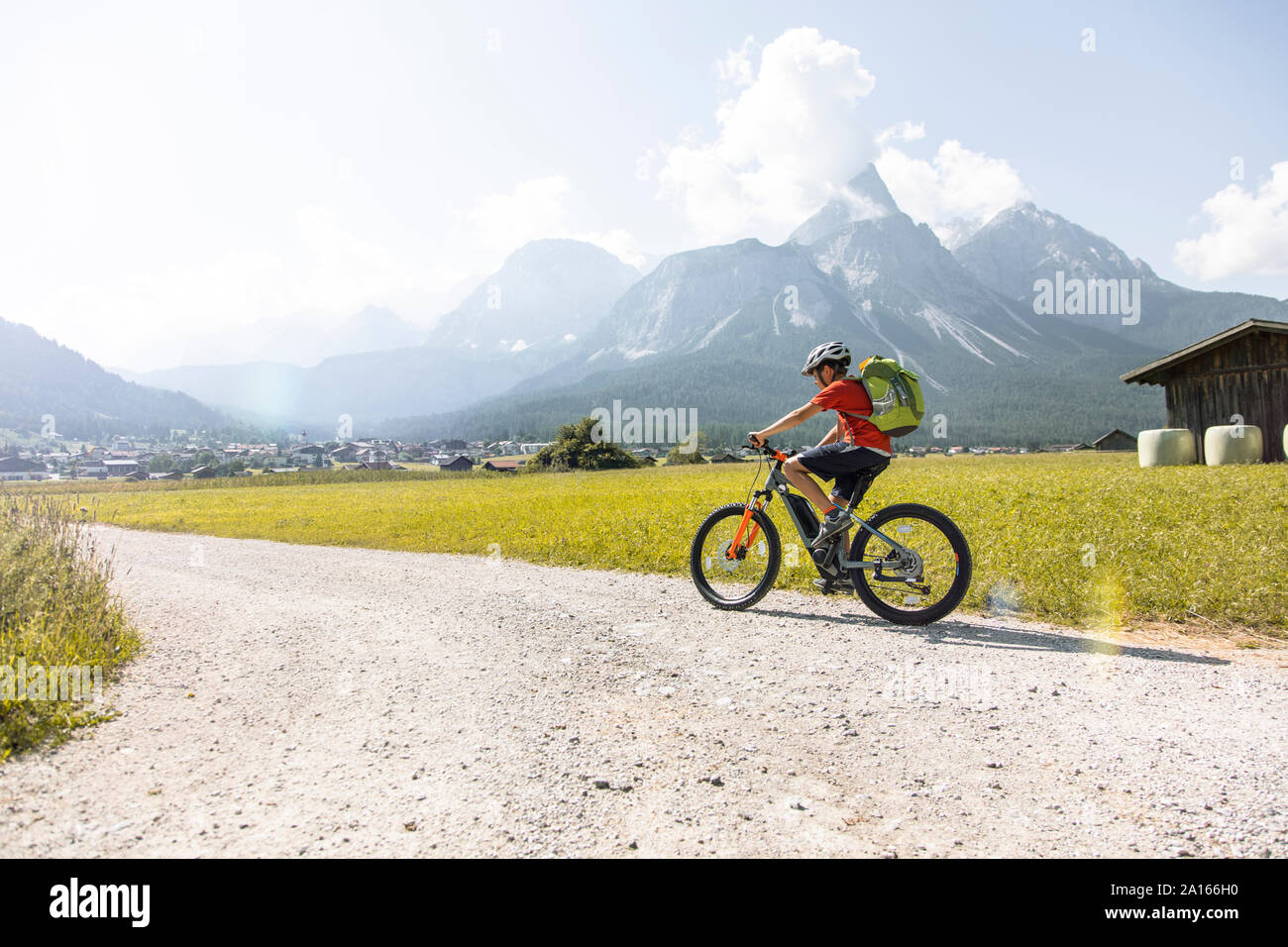 Boy riding  e-mountain bike in the mountains Stock Photo