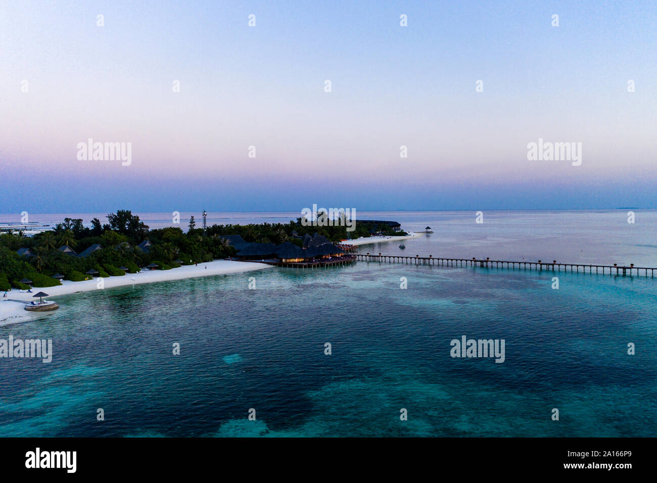 Maldives, Olhuveli island, Pier and resort on South Male Atoll lagoon at sunset Stock Photo