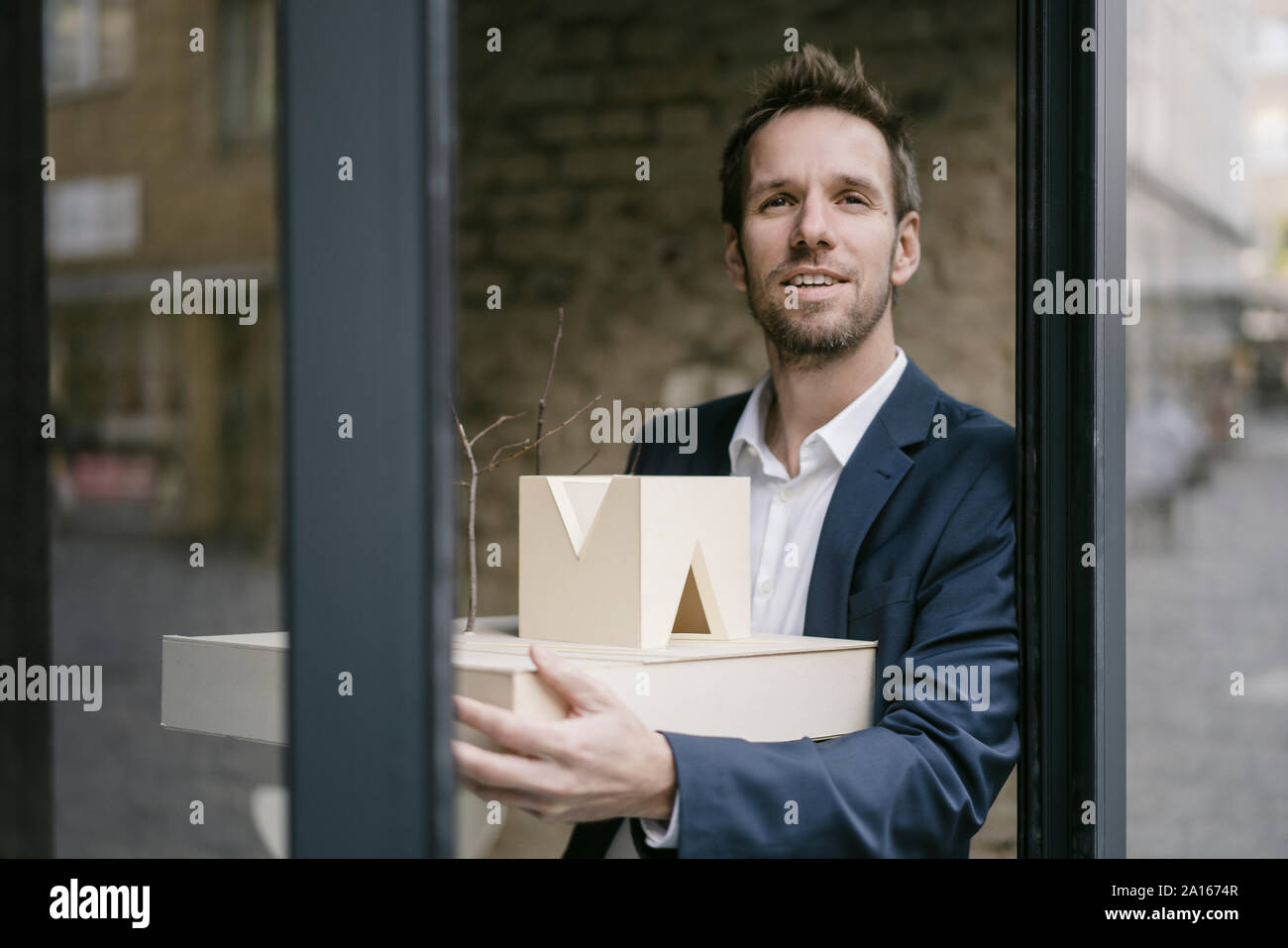 Portrait of businessman holding architectural model Stock Photo - Alamy