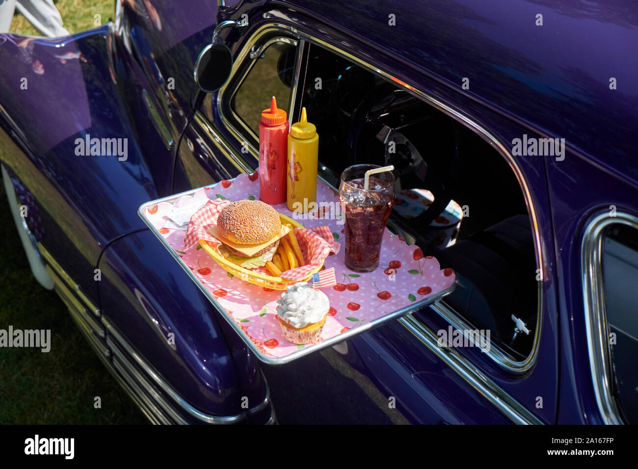 Typical American fast food on tray at vintage car, Chevrolet Fleetline Stock Photo