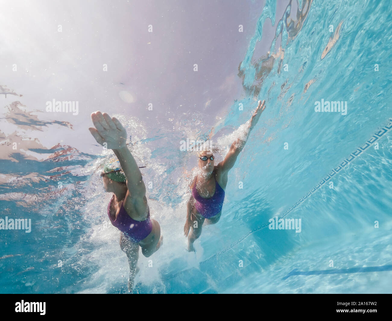 Two women swimming in a pool Stock Photo