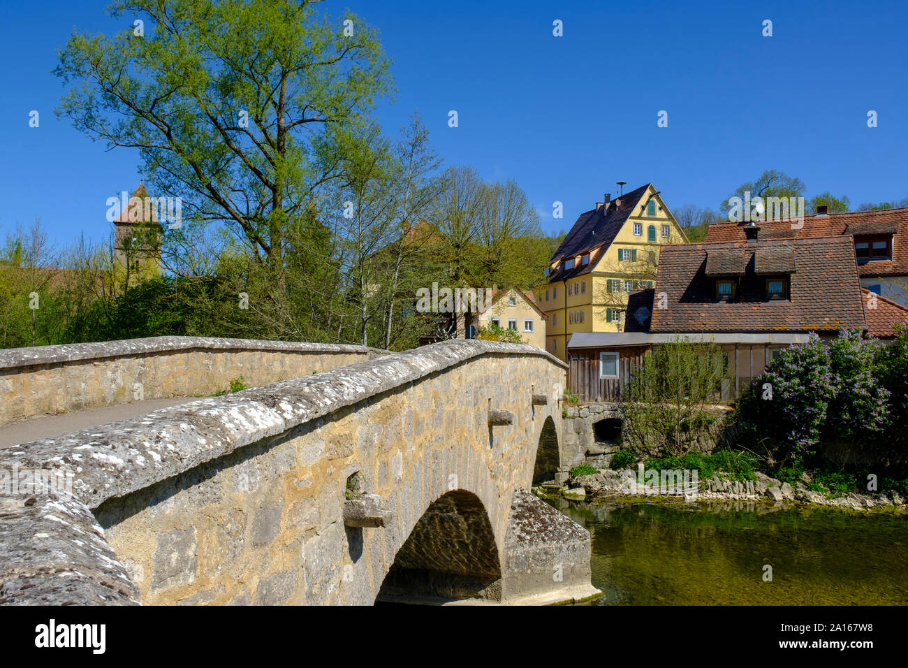 Old arch bridge over Tauber river with town houses in background, Rothenburg ob der Tauber, Bavaria, Germany Stock Photo