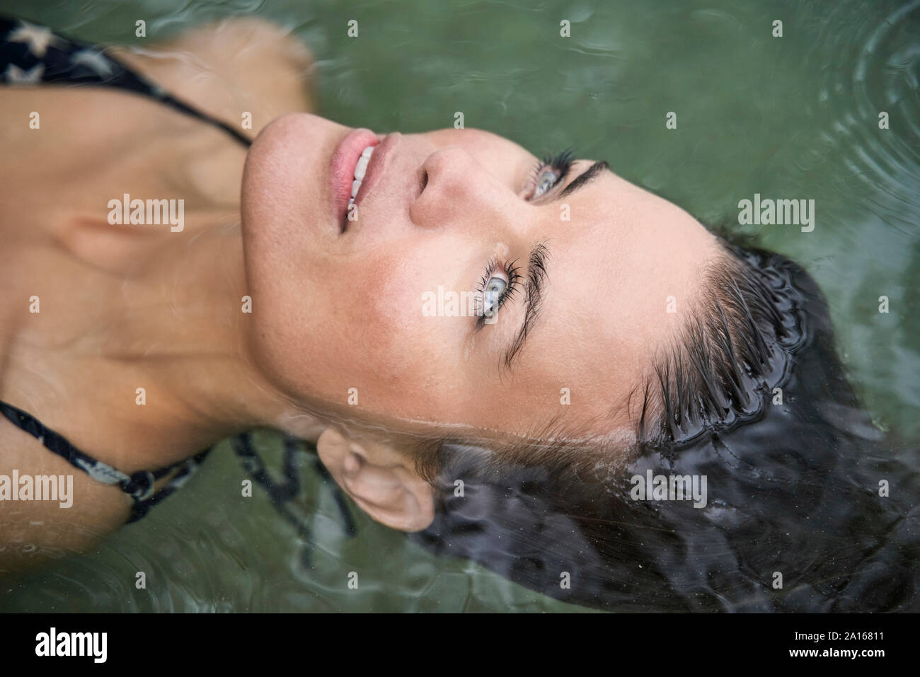 Portrait of woman floating in water Stock Photo