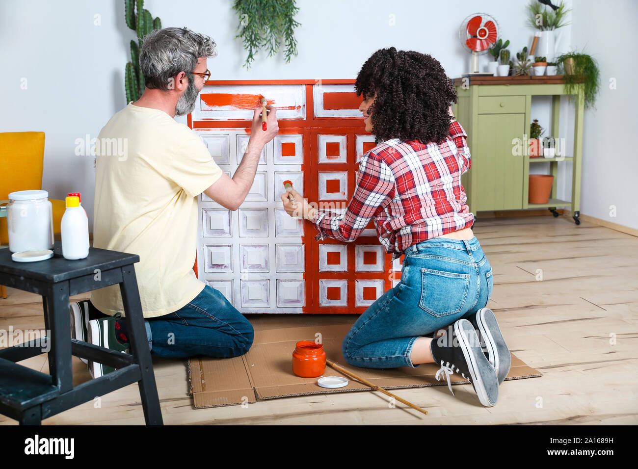 Couple painting furniture with brush at home Stock Photo