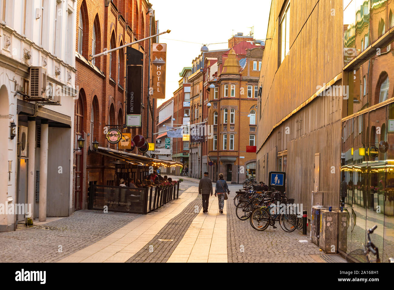 Rear view of people walking on street amidst residential buildings in Malmo city Stock Photo