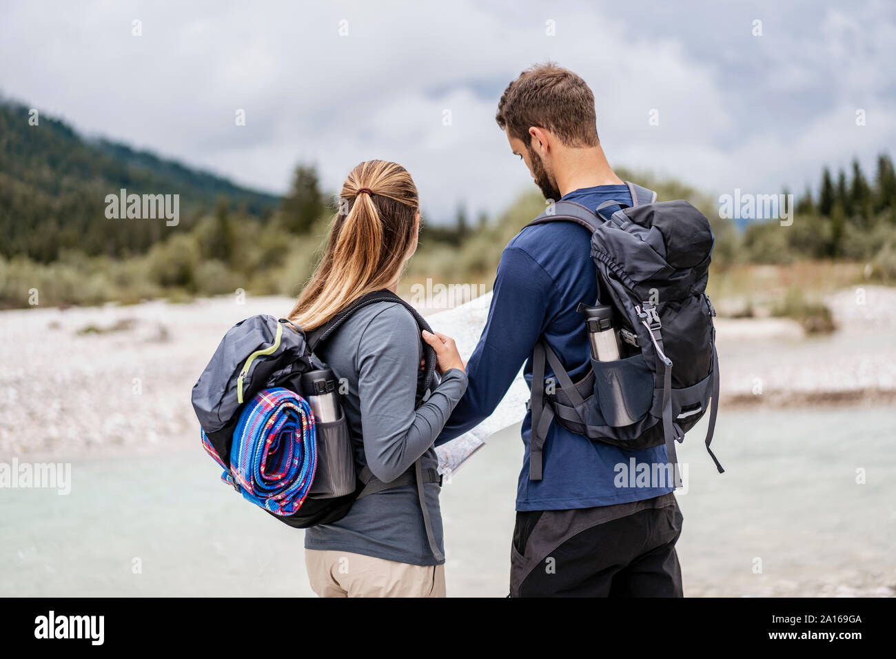 Young couple on a hiking trip reading map, Vorderriss, Bavaria, Germany Stock Photo
