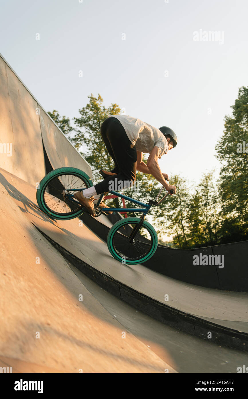 Young man riding BMX bike at skatepark Stock Photo - Alamy, image size:866x1390