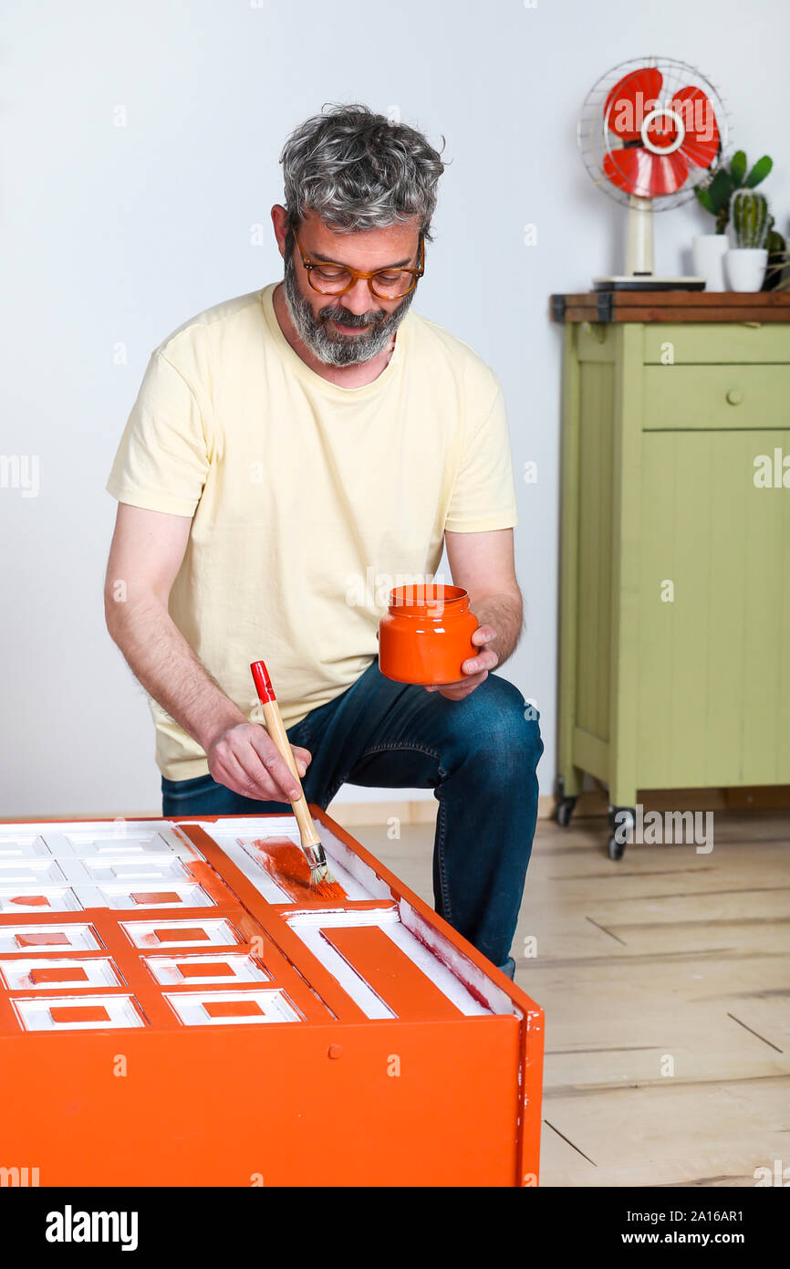 Man painting furniture with brush at home Stock Photo