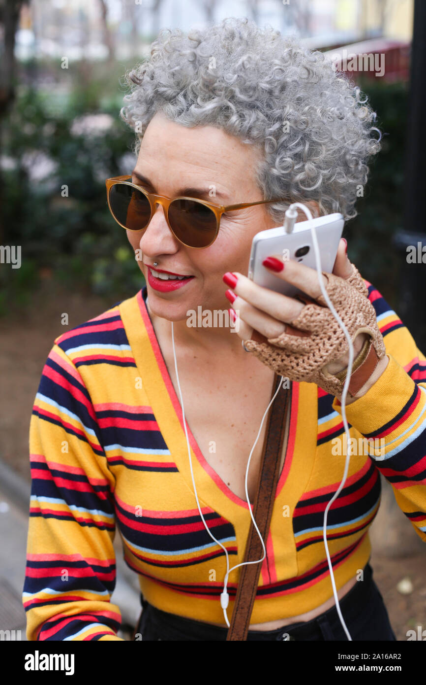 Portrait of fashionable mature woman with using smartphone outdoors Stock Photo