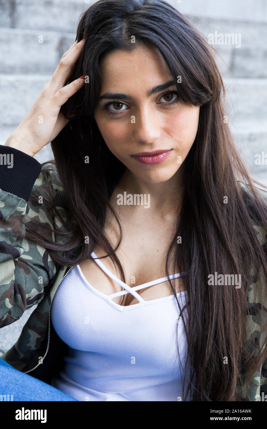 Young pretty woman touching hair and looking at camera Stock Photo