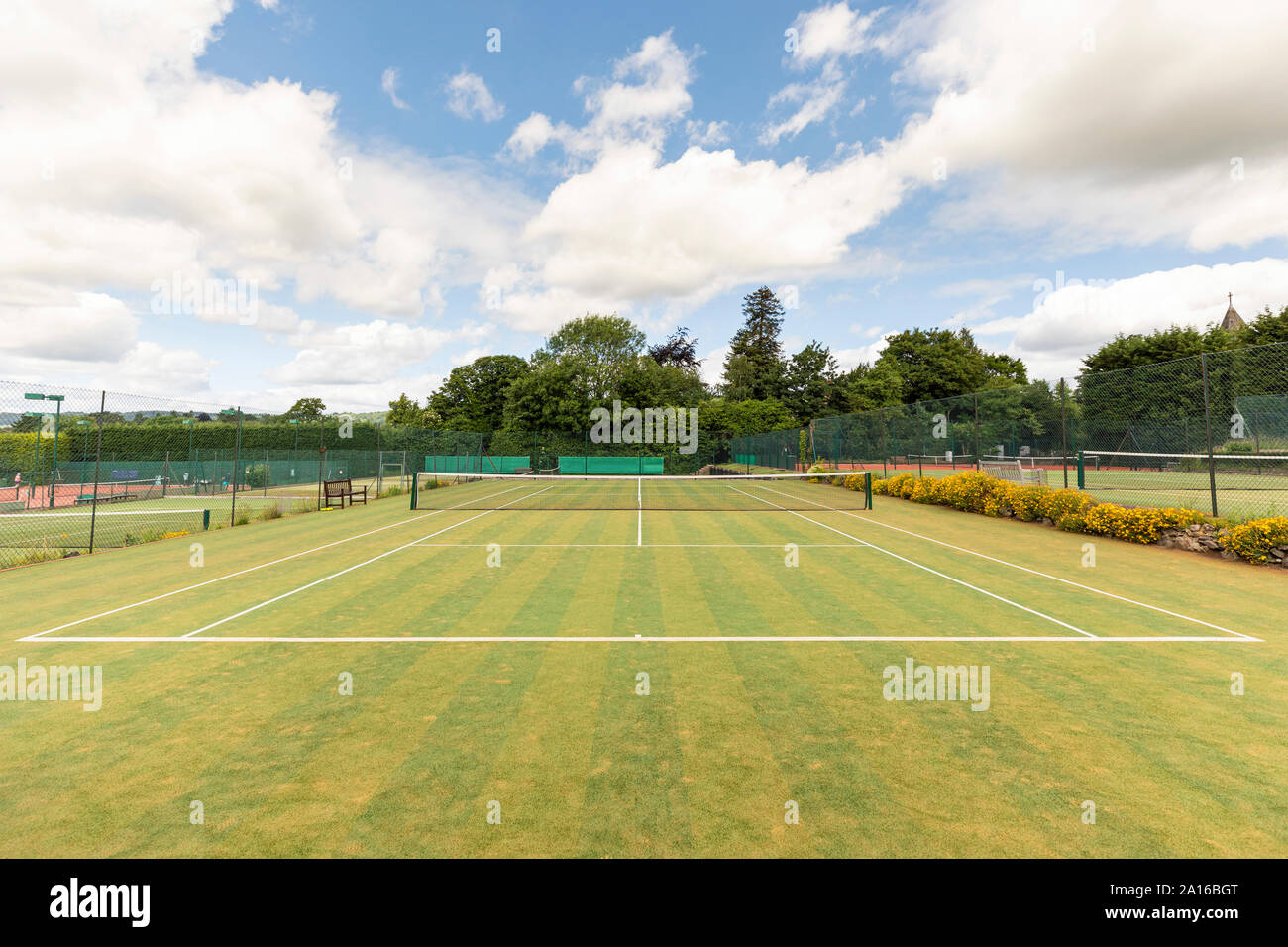 Sports net and single line markings in empty tennis court against sky Stock Photo