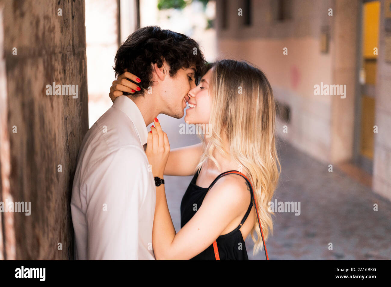 Affectionate young couple in love kissing in the city Stock Photo. 