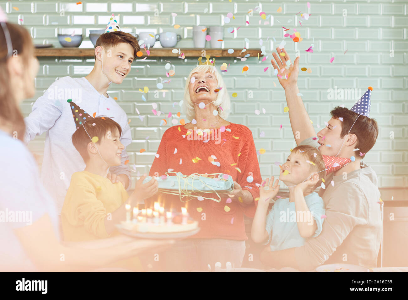 Mother and sons celebrating grandmother's bithday in their kitchen Stock Photo