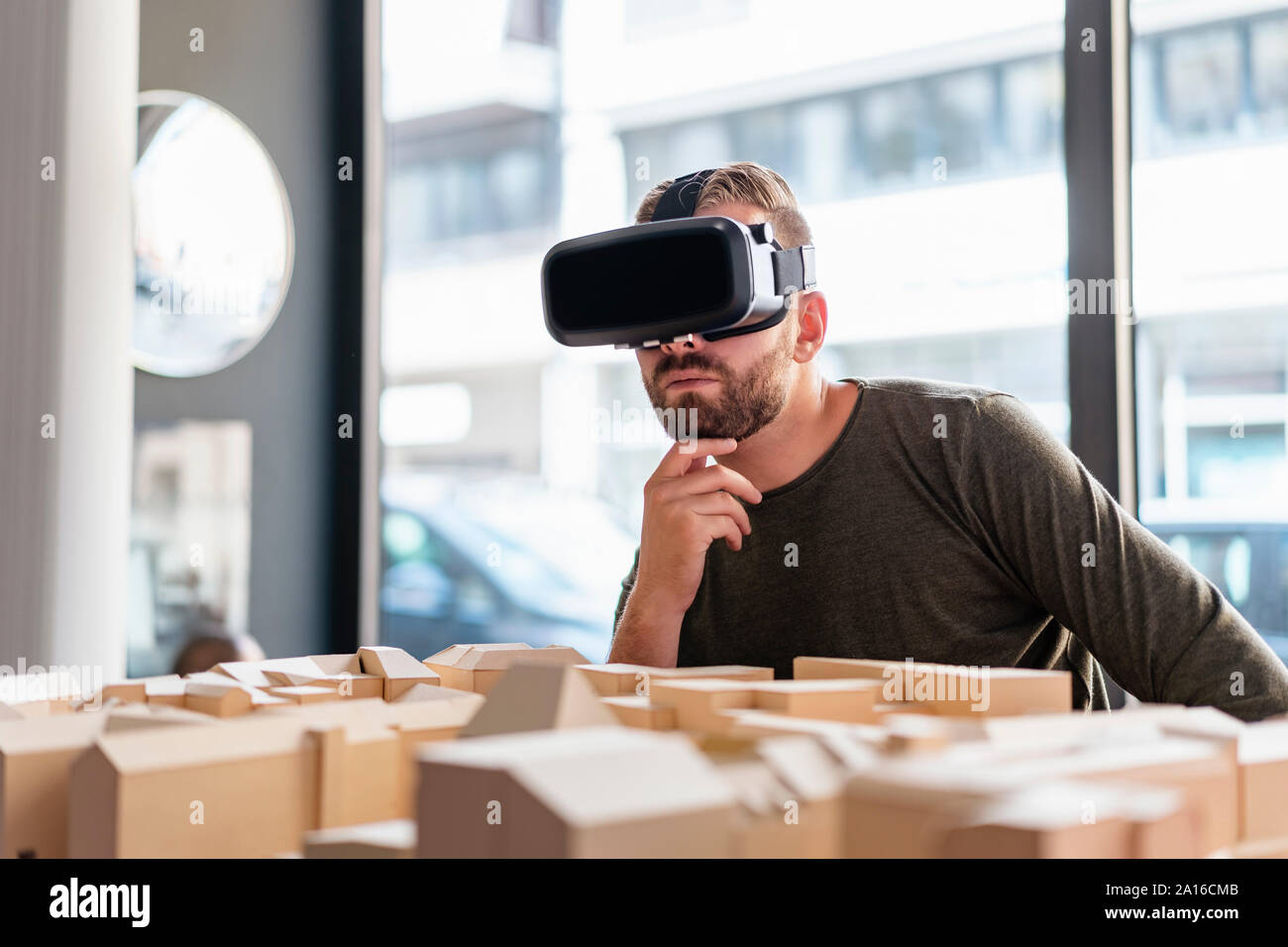 Man with architectural model in office wearing VR glasses Stock Photo