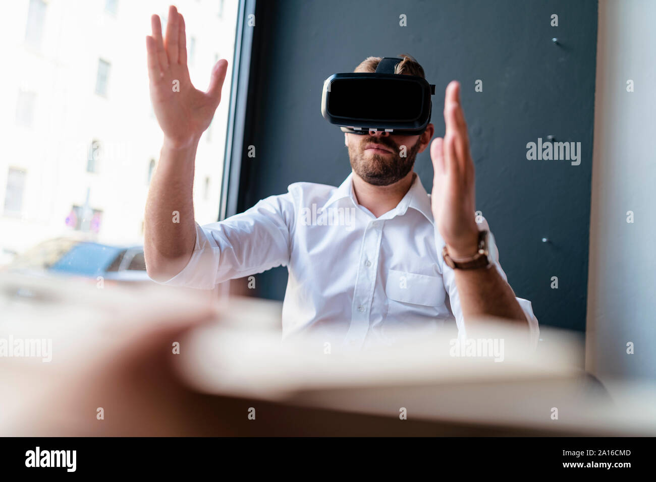 Businessman with architectural model in office wearing VR glasses Stock Photo