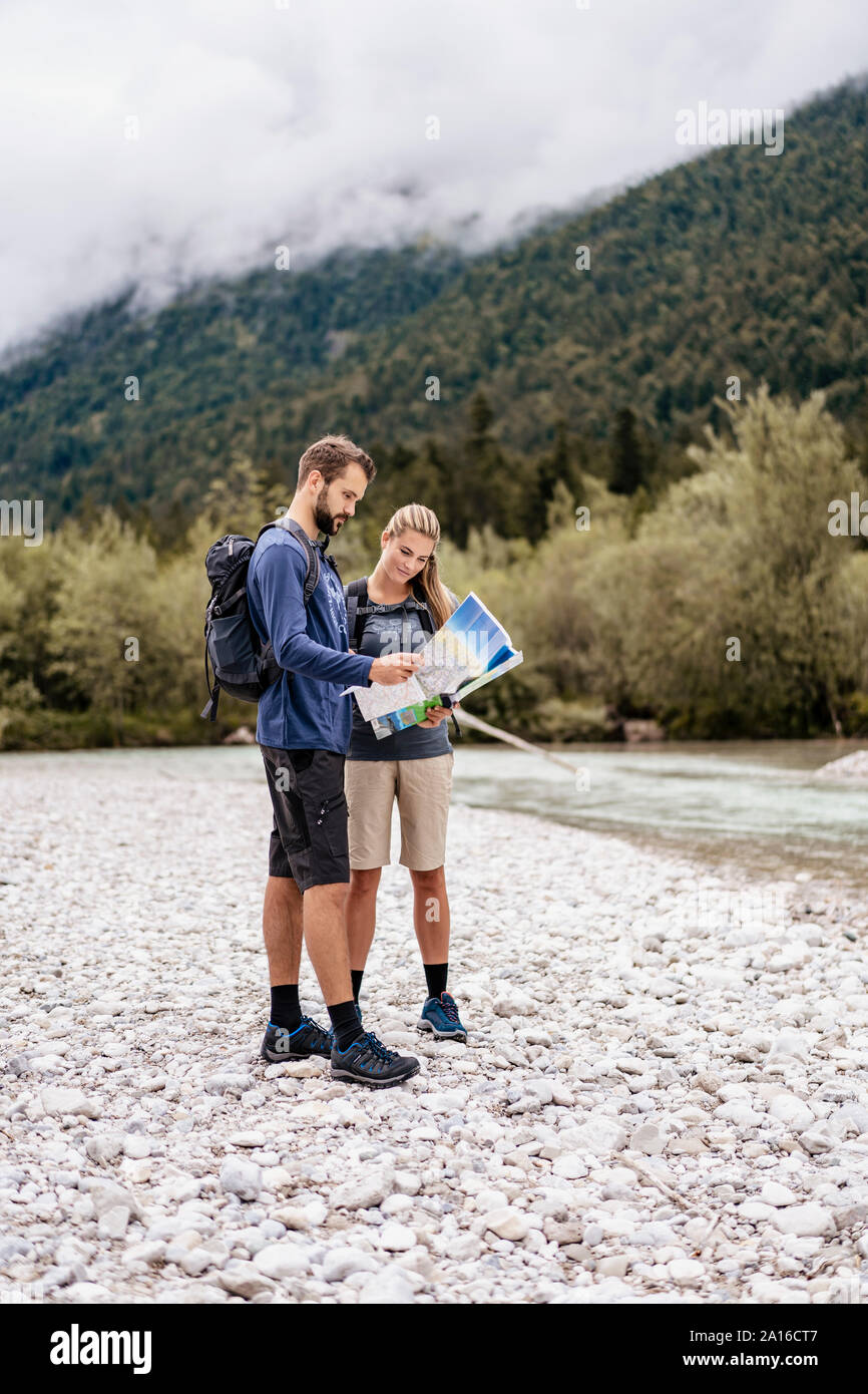 Young couple on a hiking trip reading map, Vorderriss, Bavaria, Germany Stock Photo