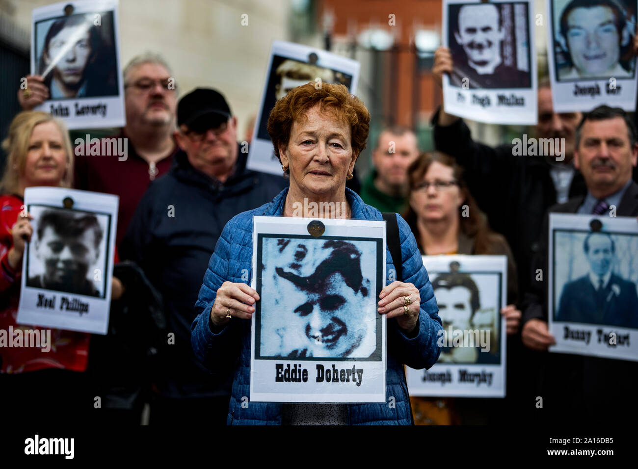 Kathleen McCarry holds an image of her late brother Eddie Doherty, who died during the disputed series of shootings in the Ballymurphy area of Belfast in August 1971. Mrs McCarry is accompanied by other families and supporters of those who died during the shootings outside Laganside Courts. Stock Photo