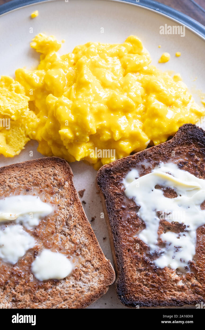 Fresh organic eggs, scrambled, with home made wholemeal bread for breakfast UK Stock Photo