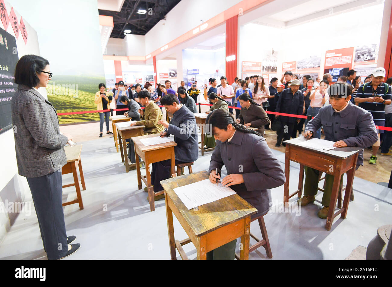 Beijing, China. 24th Sep, 2019. Visitors view a scene of China's national college entrance examination in 1977 at a grand exhibition of achievements in commemoration of the 70th anniversary of the founding of the People's Republic of China (PRC) at the Beijing Exhibition Center in Beijing, capital of China, Sept. 24, 2019. The exhibition opened to the public on Tuesday. Credit: Chen Yehua/Xinhua/Alamy Live News Stock Photo