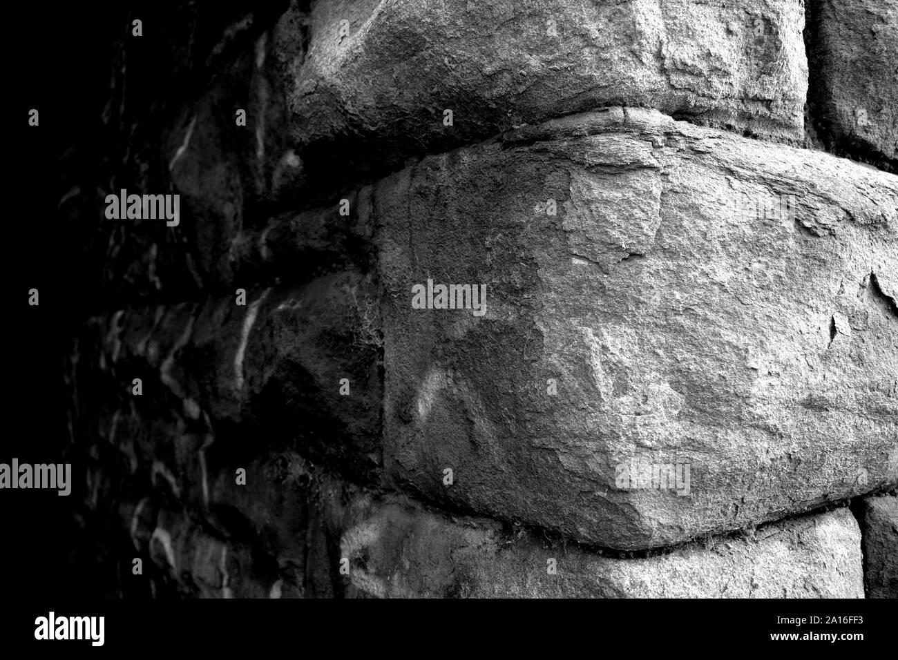 Close up of a corner of an old stone wall in black and white Stock Photo