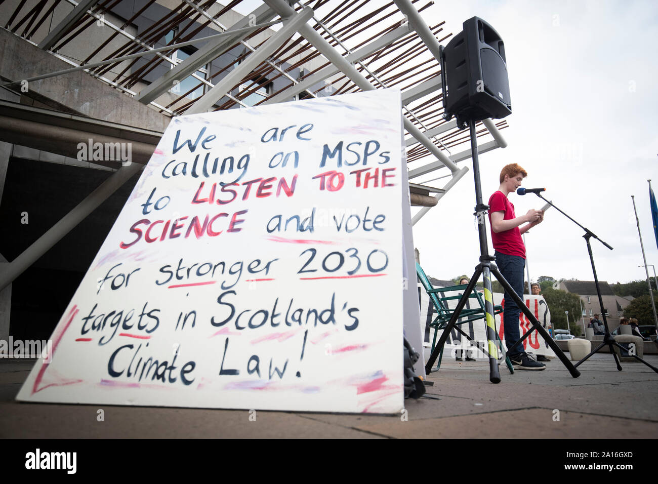 Sandy Boyd, from the Scottish Youth Climate Strike, outside the Scottish Parliament in Edinburgh ahead of MSPs casting their final vote on Scotland's new Climate Change Bill. Boyd read out the landmark UN IPCC Special Report on 1.5C that says action must increase urgently within the next decade. Stock Photo