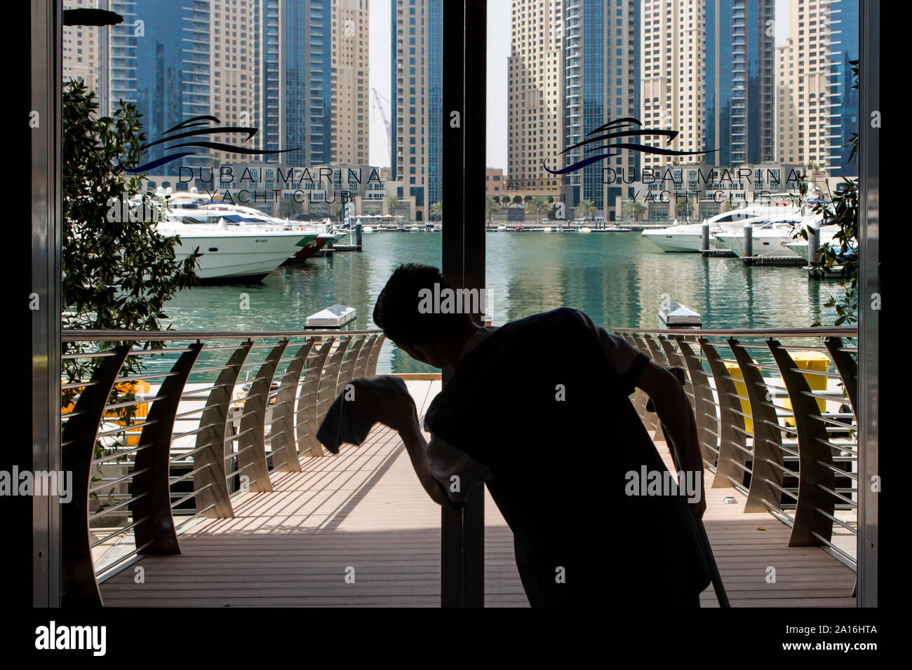 DUBAI Silhouette of a man cleaning the sliding doors towards the