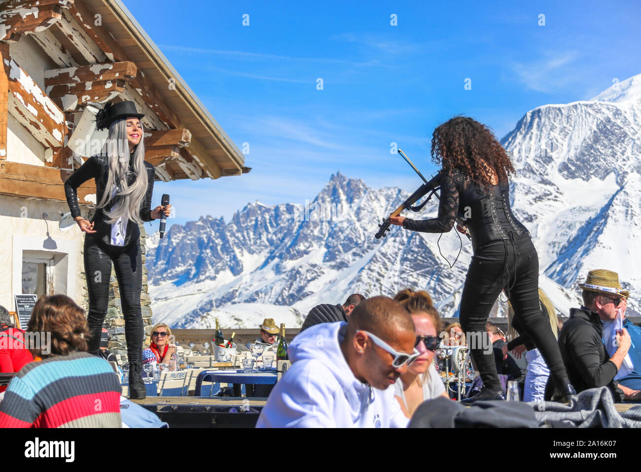 Artists perform in an after ski event, with snow capped Mont Blanc