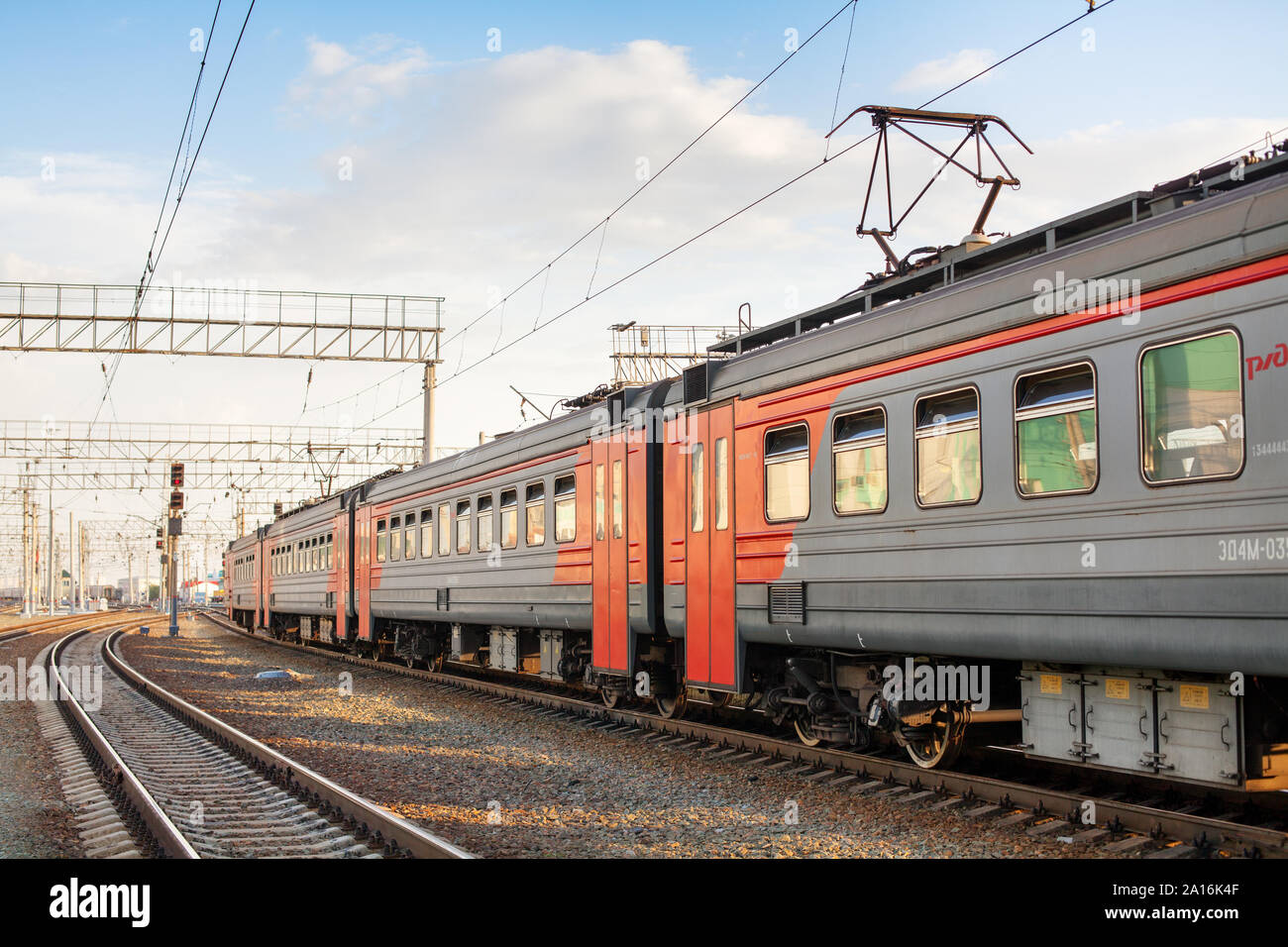 City railway station, passenger train wagons on platform close up, red