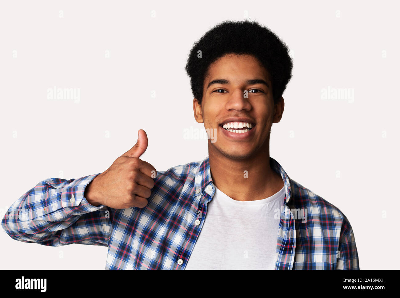 I like it. Happy afro guy showing thumb up gesture and smiling Stock Photo