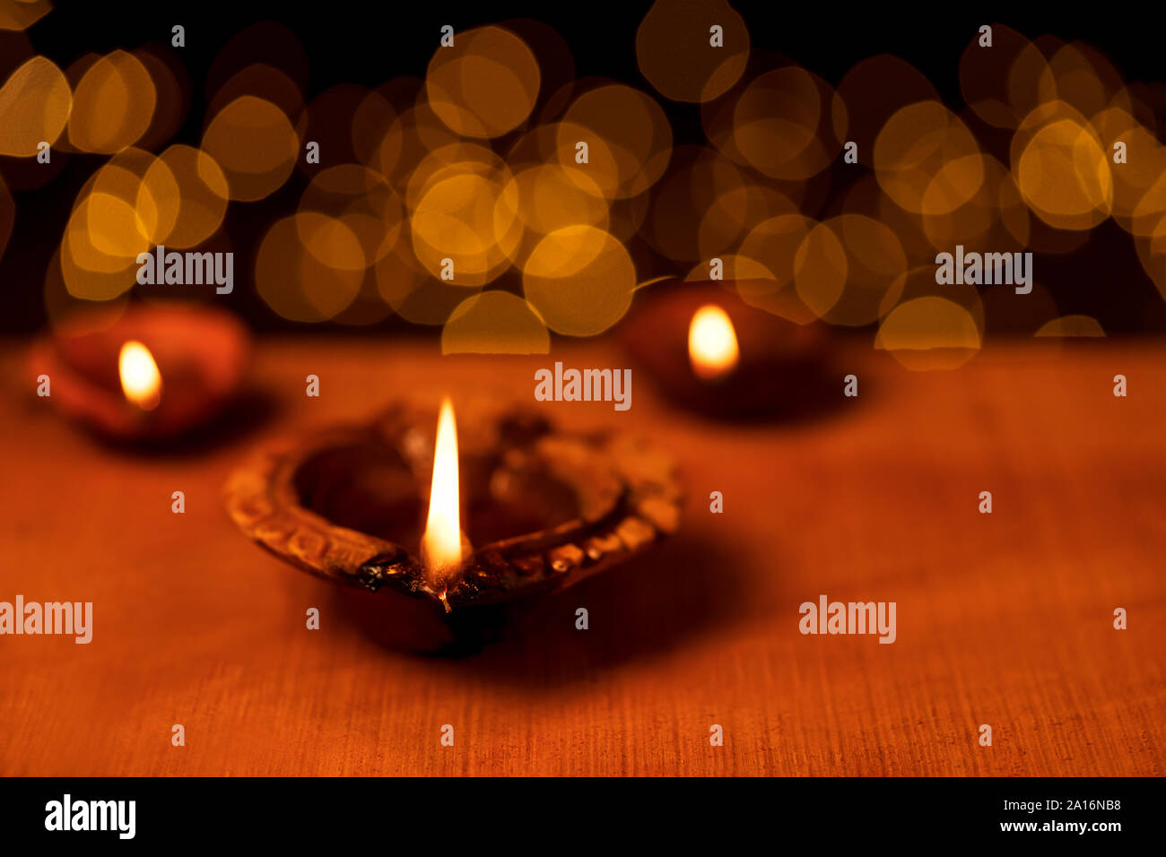 Clay diya oil lamps lit during diwali celebbration with bokeh lights in dark black background. Greetings card design for Indian Hindu light festival c Stock Photo