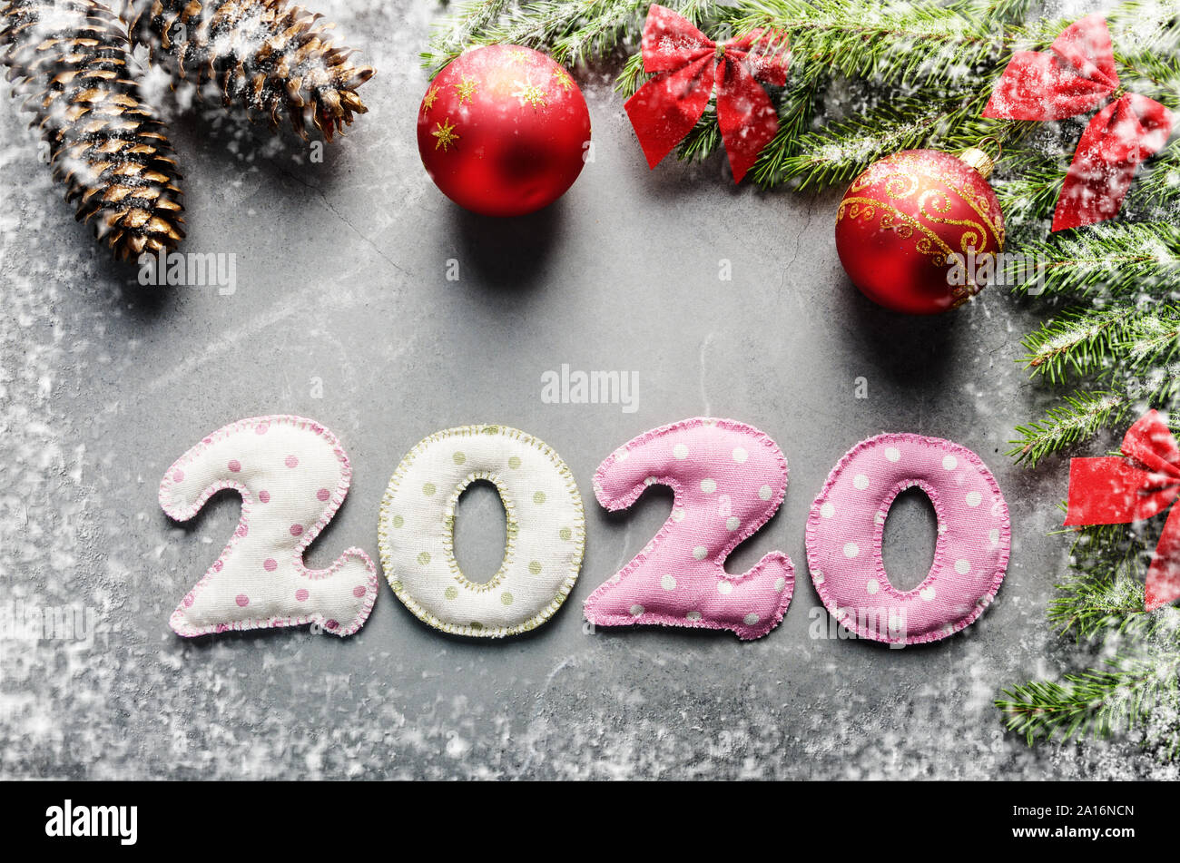 Colorful stitched digits 2020 of polkadot fabric with Christmas decorations flat lay on stone background Stock Photo