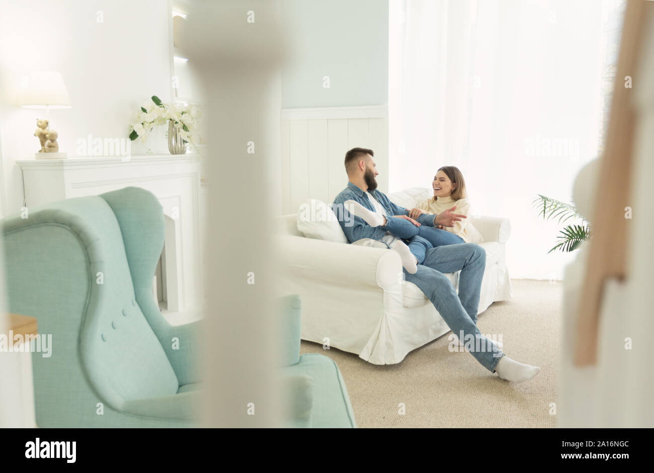 Love story. Happy couple sitting on sofa, in light interior room Stock Photo