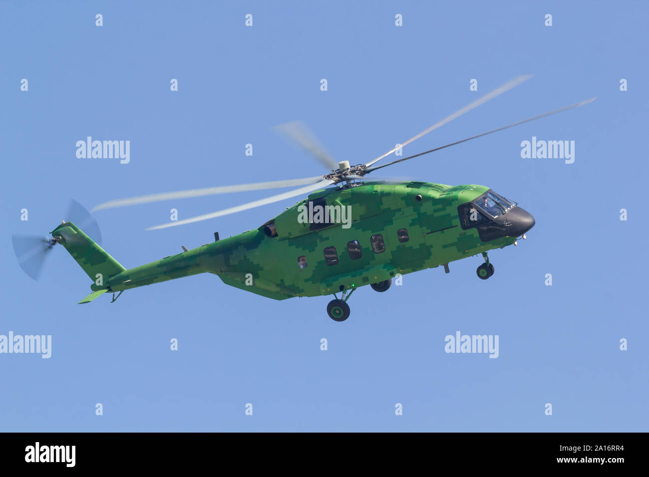 A military bright green helicopter flying in the blue sky - side view. Mid  shot Stock Photo - Alamy