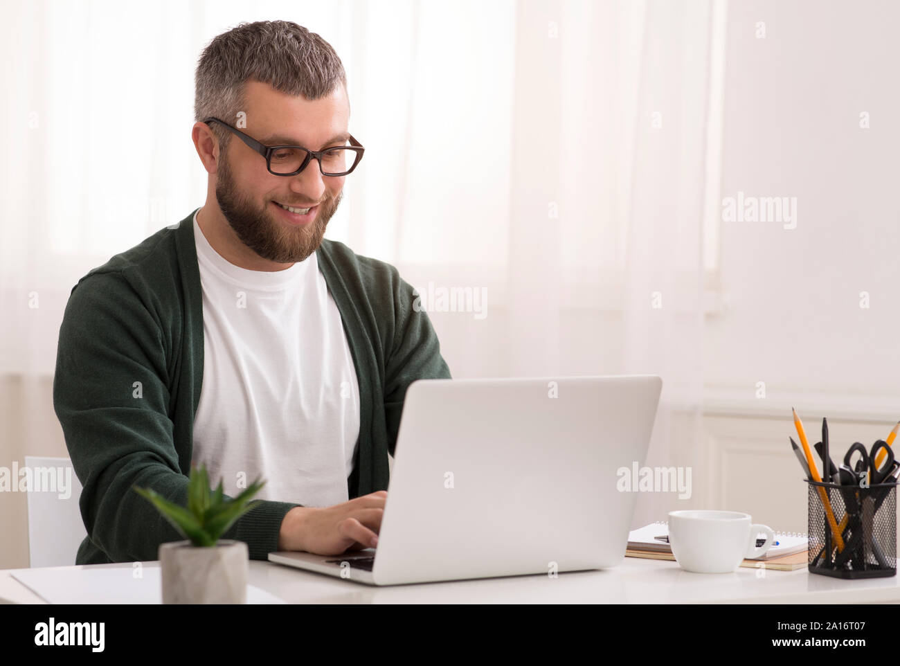 Middle aged man enjoying his job, working from home Stock Photo