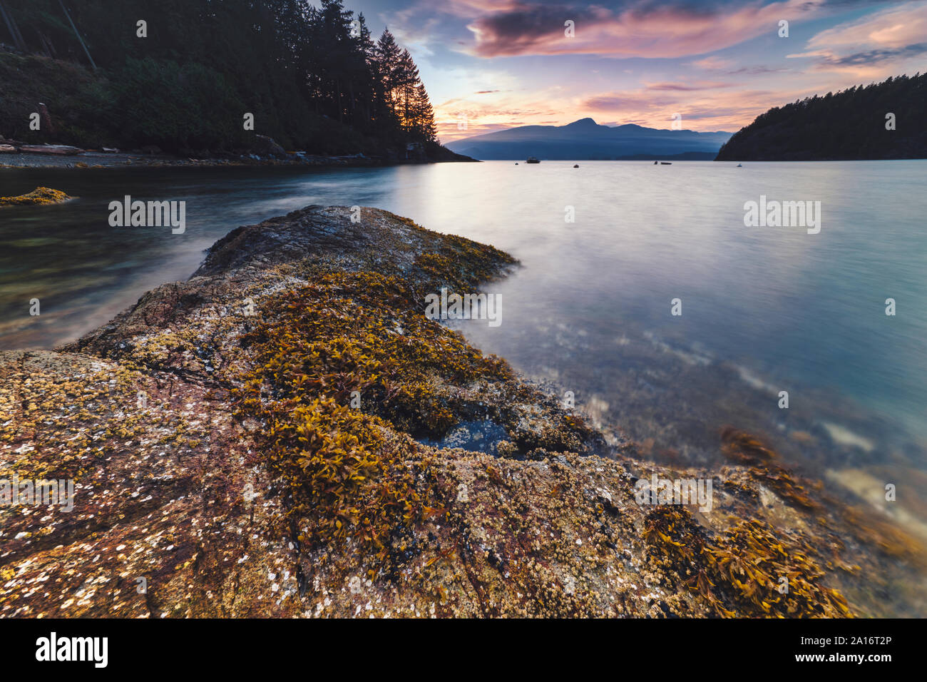 Rocky beach sunsets along the Pacific North West's Bowen Island in Howe Sound with spectacular lighthouse views all just off the coast of Vancouver BC Stock Photo