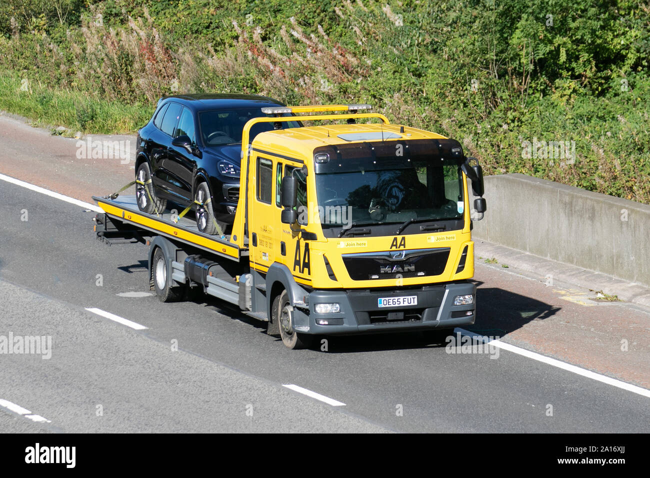 AA Flatbed truck emergency breakdown rescue vehicle; UK Vehicular traffic, transport, modern, saloon cars, south-bound on the 3 lane M6 motorway highway. Stock Photo