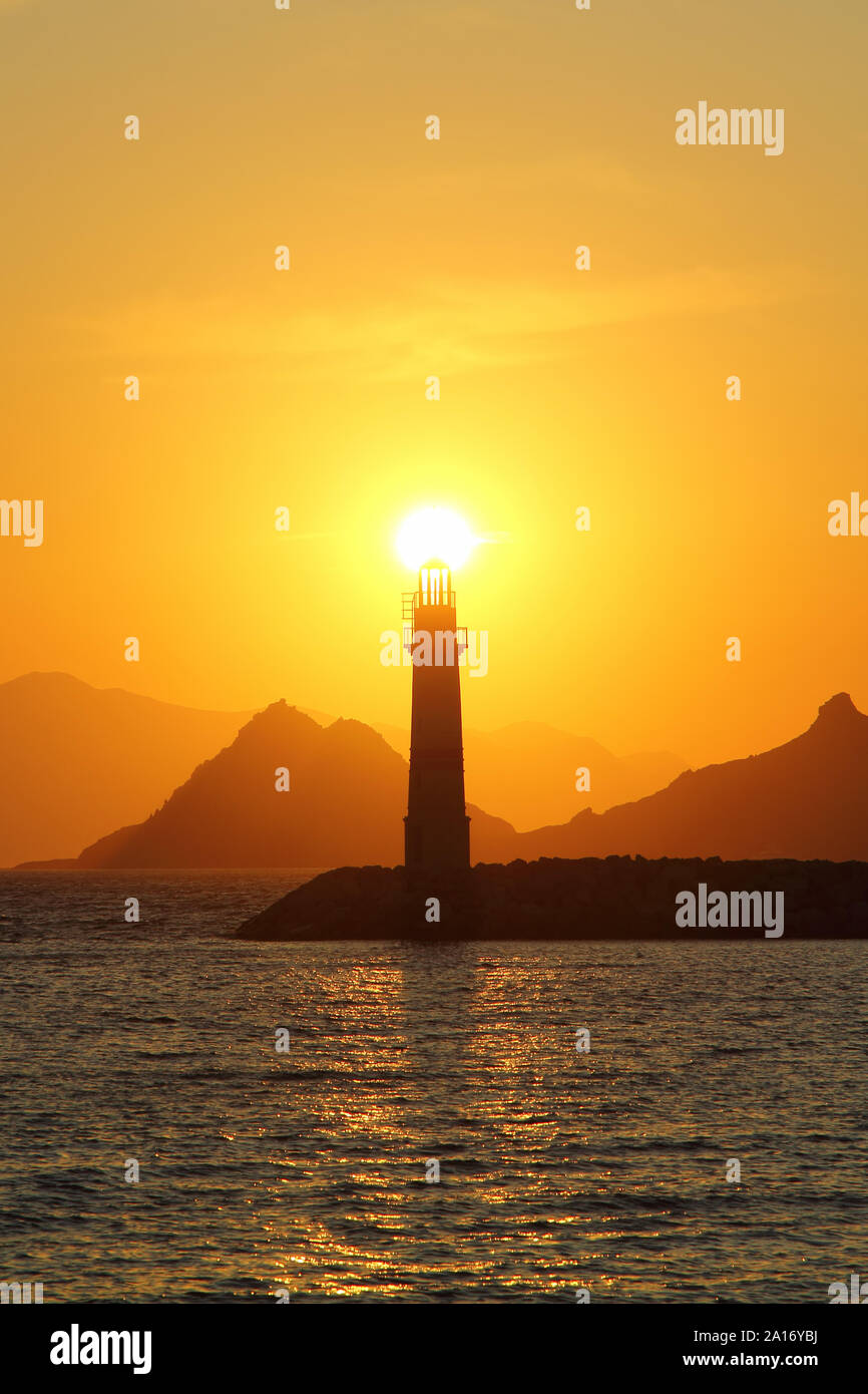 Seascape at sunset. Lighthouse on the coast. Seaside town of Turgutreis and spectacular sunsets Stock Photo