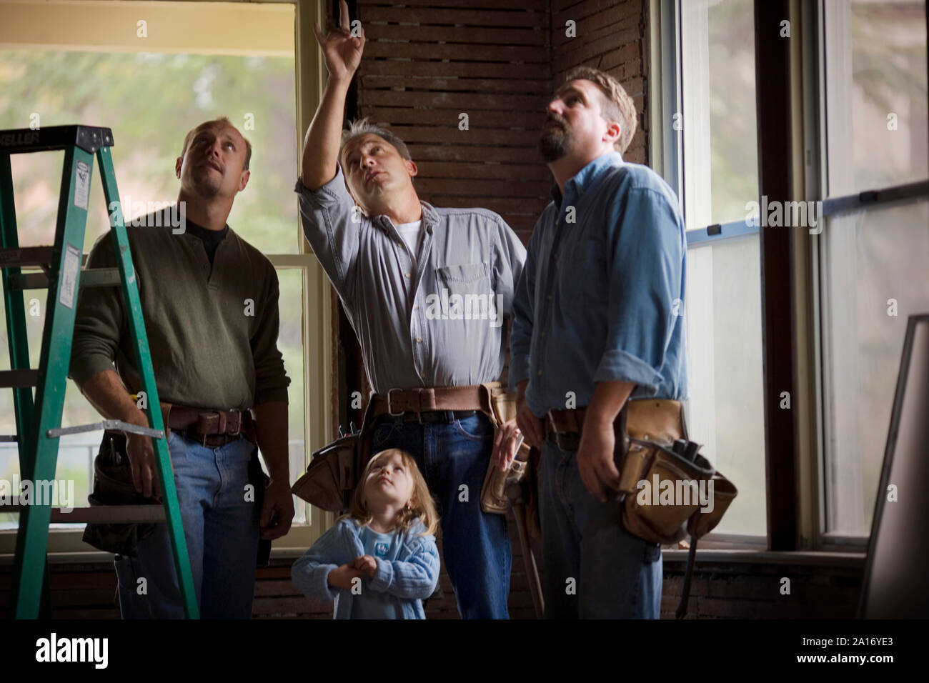 Four male builders standing in a room with a young child Stock Photo ...