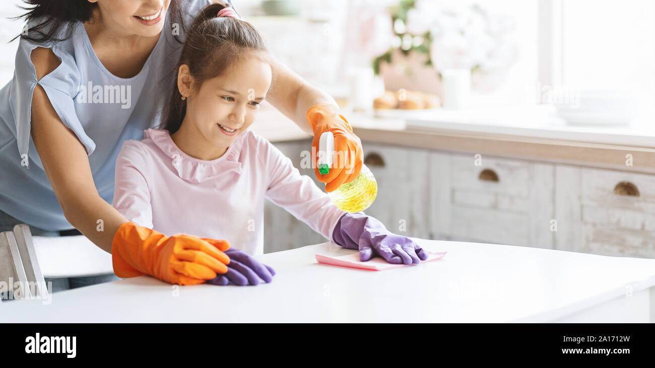 Cute girl helping mom to clean table from dust Stock Photo Alamy