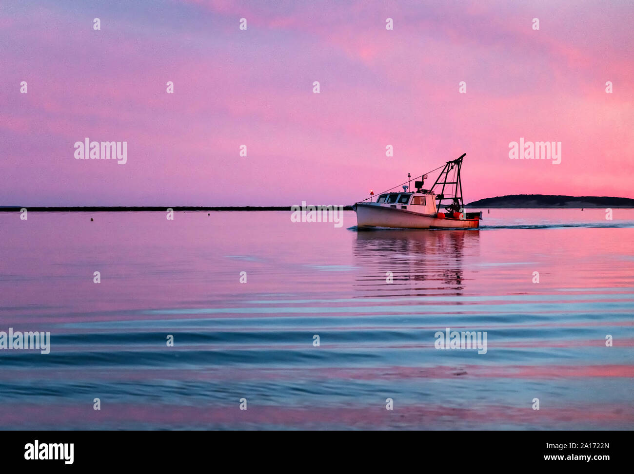 Commercial fishing boat returns to harbor at sunset, Wellfleet, Cape Cod, Massachusetts, USA. Stock Photo
