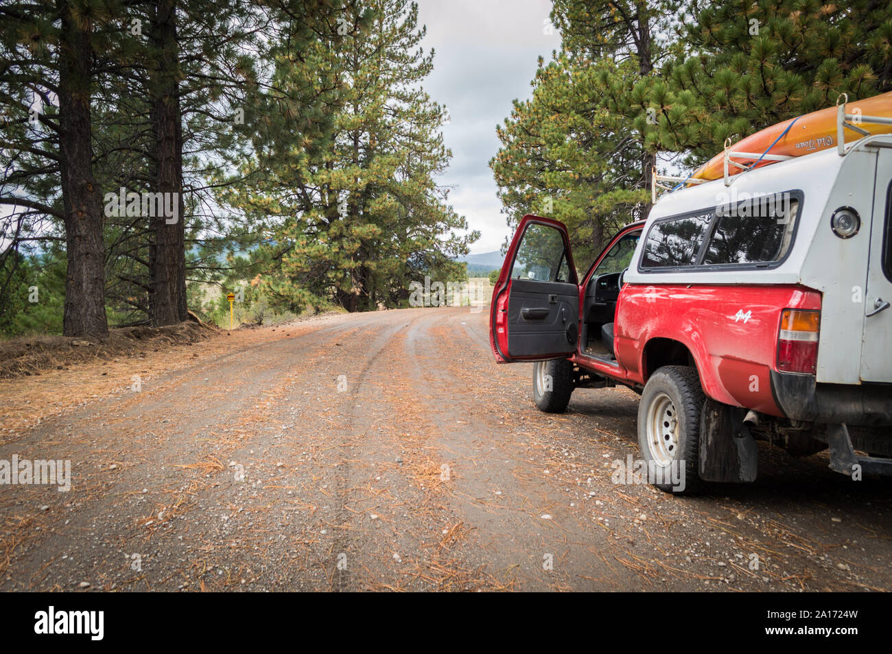 Truckee, California / USA - Sept 08 2019: A four wheel drive camper truck parked on the side of a dirt road leading into a forest. Stock Photo
