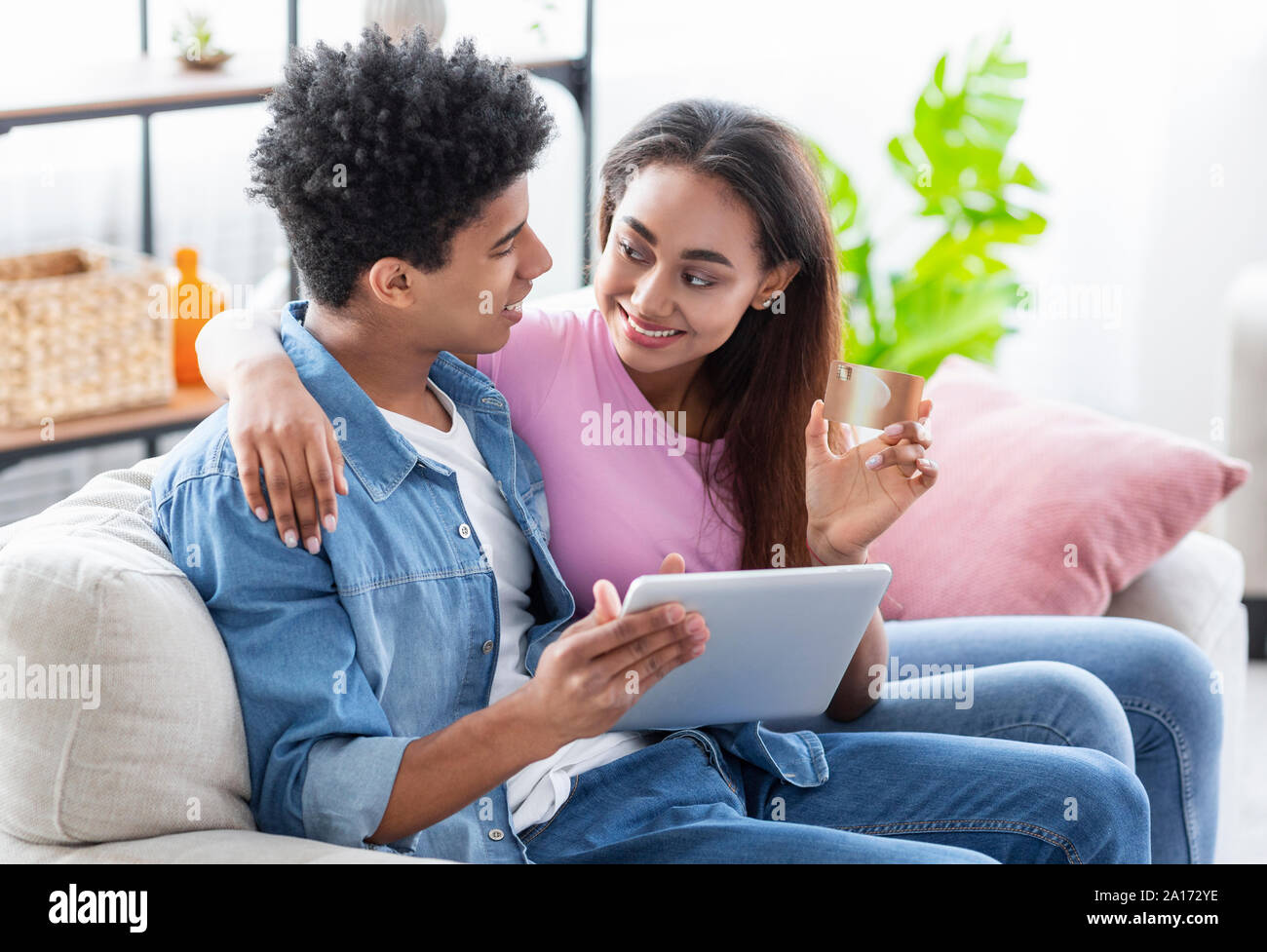 Young Couple Using Tablet And Credit Card At Home Stock Photo