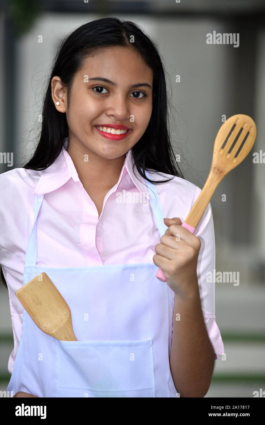 A Female Cook With Utensils Stock Photo
