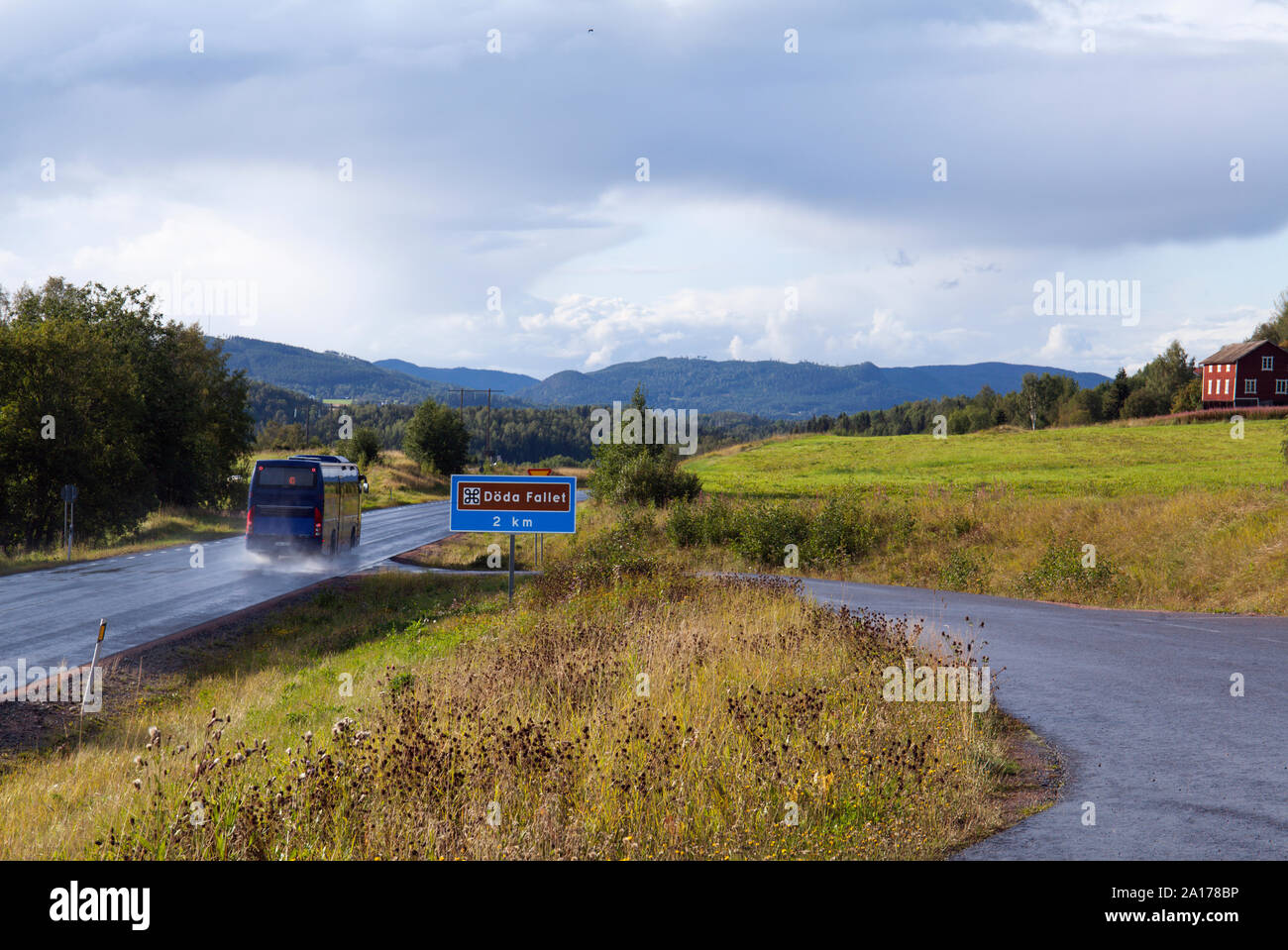 RAGUNDA, SWEDEN ON AUGUST 23, 2019. View of a bus in speed, road sign in the landscape. Editorial use. Stock Photo