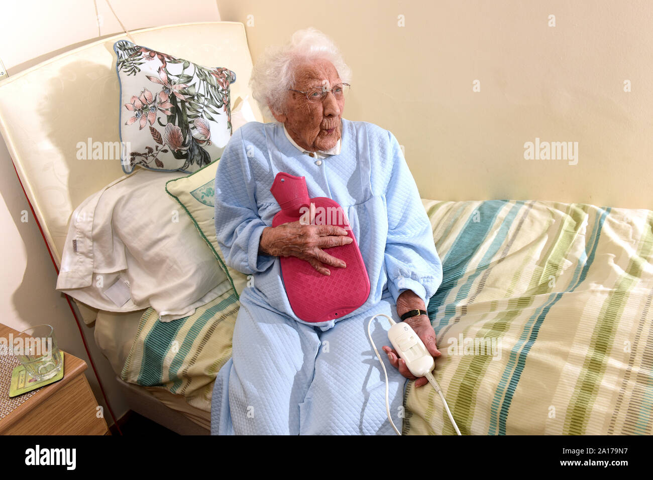 Elderly lady going to bed with an electric blanket and hot water bottle Britain Uk Stock Photo