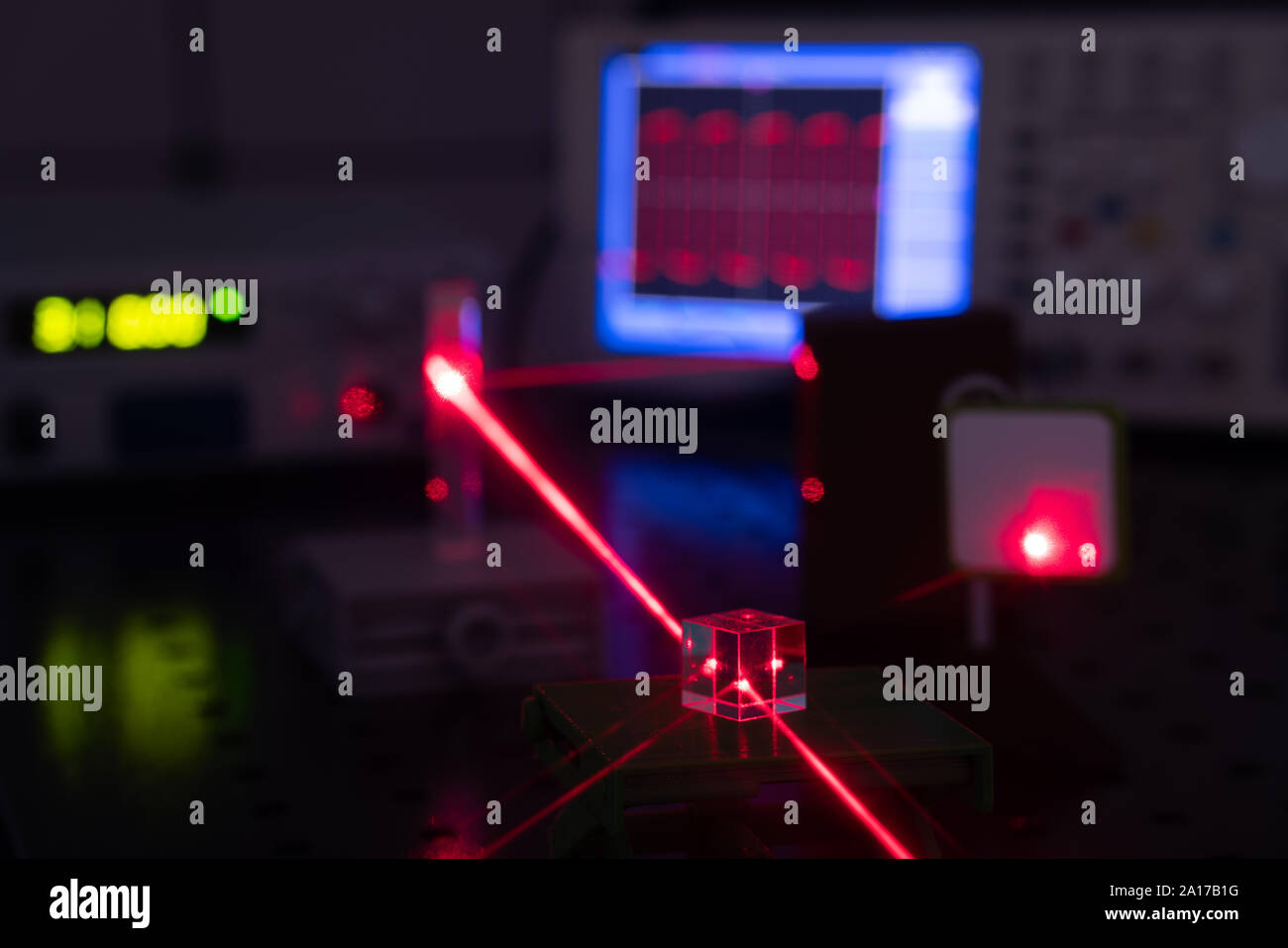 Experiment in optic lab with laser device. Red laser on optical table in physics laboratory